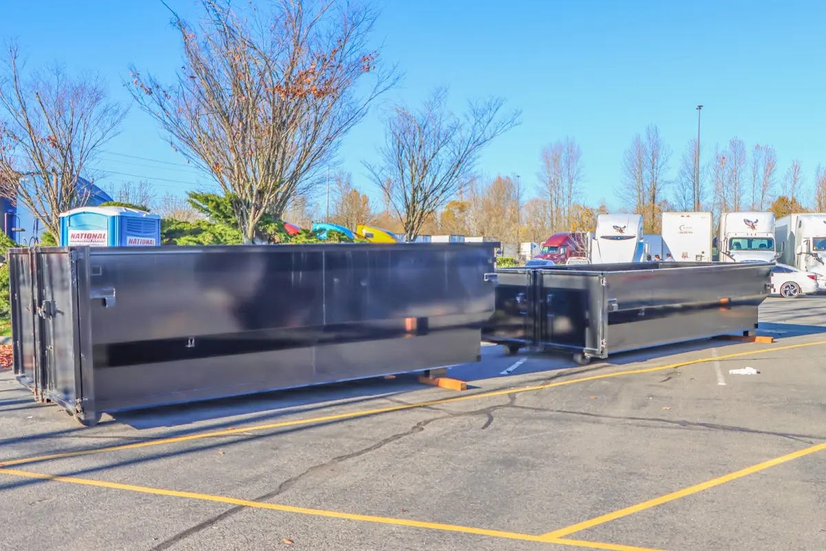 Professional dumpster rental service with roll-off container on residential driveway in Kingsland